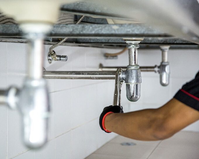 a plumber repairing a leaky pipe
